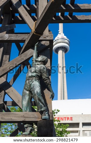 TORONTO,CANADA-JUNE 15,2015: The Chinese Railway Workers Memorial in front of Rogers Centre and the CN Tower in the background. The landmark is dedicated to the Chinese railroad workers