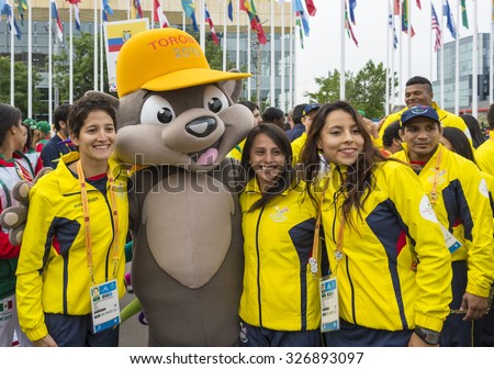 TORONTO,CANADA-JULY 8,2015:Athletes from Ecuador posing for photograph with the mascot Pachi the Porcupine at the 2015 Pan Am Games.They were a major international multi-sport event