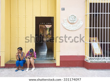 SANCTI SPIRITUS,CUBA-SEPTEMBER 19,2015:Two women sitting outside the Union of Writers and Artists of Cuba building. The signage on the building reads Union de Escritores y Artistas de Cuba.