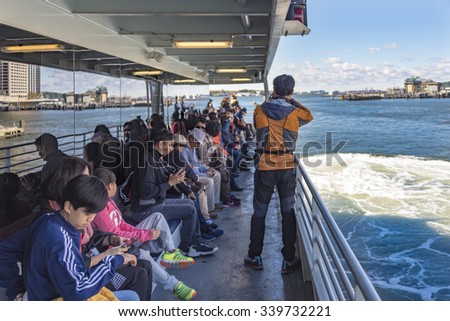 NEW YORK,USA-JULY 3,2015:New York Cruise tour: Tourists enjoying the cruise ride in the New York waters, taking photographs of the Manhattan from a cruise ship.