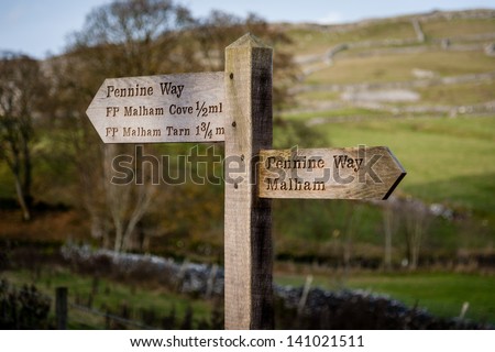 A wooden direction sign to Malham Cove and Pennine Way.