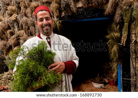 MOROCCO- ESSAOUIRA, MARCH 22, 2011: A herb and spice merchant outside his shop in Essaouria, Morocco.