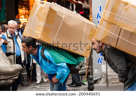 ISTANBUL, TURKEY - SEPTEMBER 21: A troop of street porters in Istanbul help to secure the cargo onto a lorry, on September 21,2012 in Istanbul.