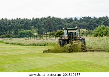 A tractor being used to cut grass at a commercial turf growing farm in Scotland.