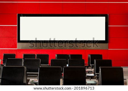 Blank billboard on modern red wall in airport with seating,