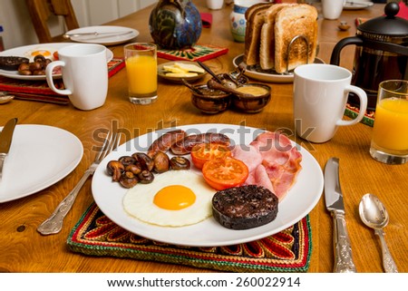 Cooked Scottish breakfast containing toast, fried egg, grilled black pudding, sausage, tomato, mushrooms and bacon.