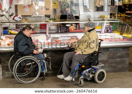 BARCELONA, SPAIN - March 7, 2012: Two disabled men in wheelchairs shopping at a food store on March 07, 2012 in Barcelona, Spain.