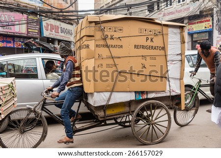 DELHI , INDIA - JANUARY 24: A bicycle rickshaw porter with large load in crowded streets on January, 24 2015 in Old Delhi, India.
