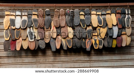 CAIRO, EGYPT - NOVEMBER 20, 2011:  A selection of shoe soles hanging outside a shoe repair shop in Cairo.