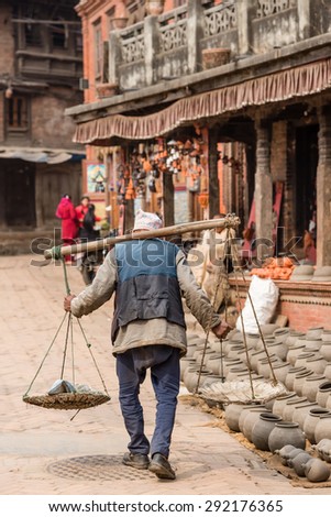 BHAKTAPUR, NEPAL - FEBRUARY 14,  2015: An elderly man working as a porter in Bhaktapur, Nepal.