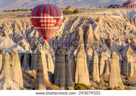 GOREME , TURKEY - OCTOBER 17, 2009: Commercial hot air balloon flying over rock formations near Goreme in Cappadocia, Turkey.