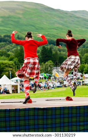 LOCHEARNHEAD, SCOTLAND- JULY, 24,2010: Two girls in traditional dress compete in the sword dance event at Highland Games on July, 24, 2010 in Lochearnhead.