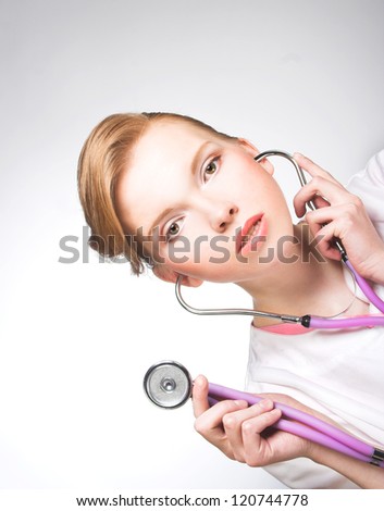 Portrait of young woman in doctor\'s smock and with stethoscope