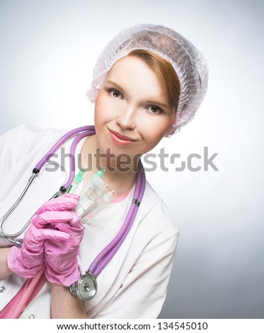 Portrait of young woman in doctor\'s smock and with ampule\'s.