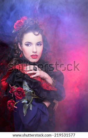 Spanish lady. Portrait of young woman in artistic image posing with smoke.