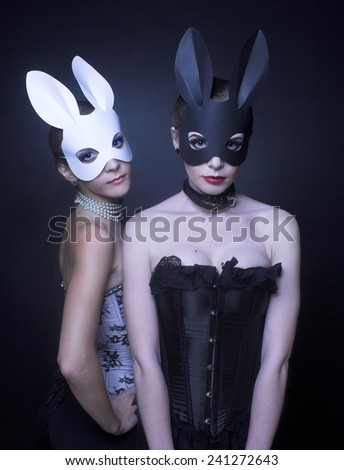 Black and white rabbits. Two young women in masks.