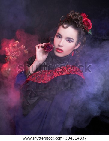 Spanish lady. Portrait of young woman in artistic image posing with smoke.