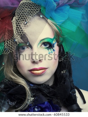 Romantic portrait of young woman with bright creative make-up in fantastic hat