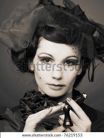 Young woman in creative image with chess in her hangs