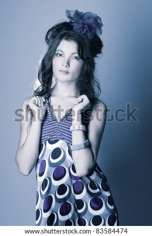 Young charming woman in modern dress with bright visage and with long dark hair and bow.