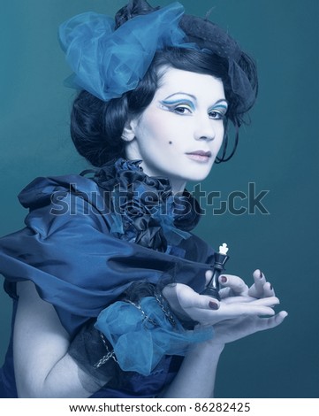 Young woman in creative image with chess in her hangs