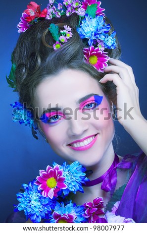 Romantic portrait of charming woman with artistic visage and flowers in her hair.