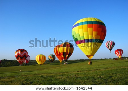 hot air balloons landing in a field