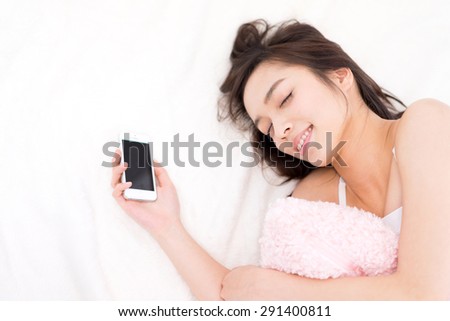 smart phone addiction - young woman sleeping with smart phone