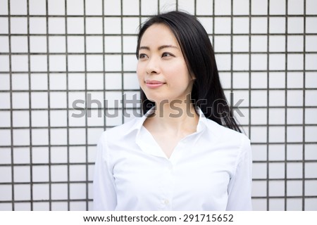 young business woman against white tile wall