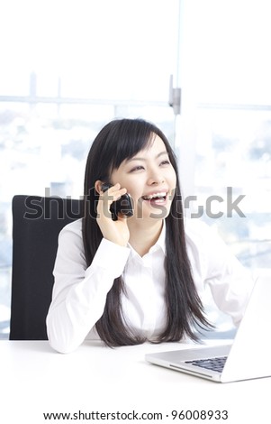 young business woman talking on mobile phone at office