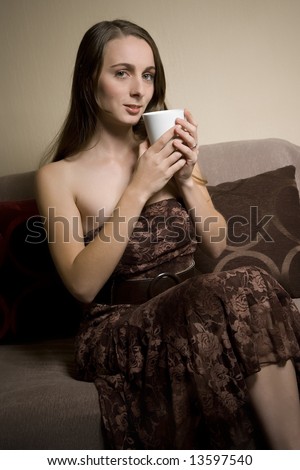 Lovely lady hold coffee mug on sofa