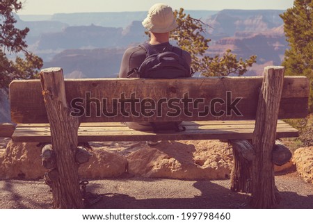 Man on bench in Grand Canyon, vintage filter