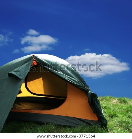 Green camping  tent on sunny grassland
