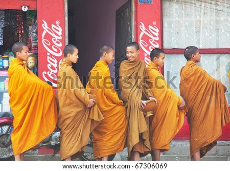 KATHMANDU, NEPAL - APRIL 12: Unidentified young monks stay in line to collect alms and offerings on April 12, 2010 in Kathmandu, Nepal. This procession is held every day.