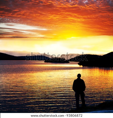 man silhouette at sunset lake, Norway