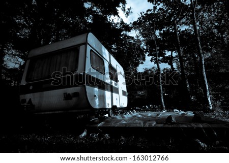 Vintage camper van on a parking lot at the night - horror movie scene