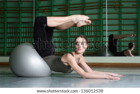 Attractive Woman Exercising With Exercise Ball At dance hall