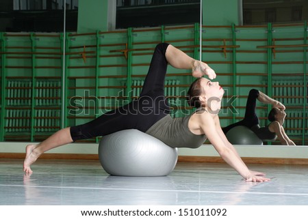 Attractive woman exercising with exercise ball at dance hall