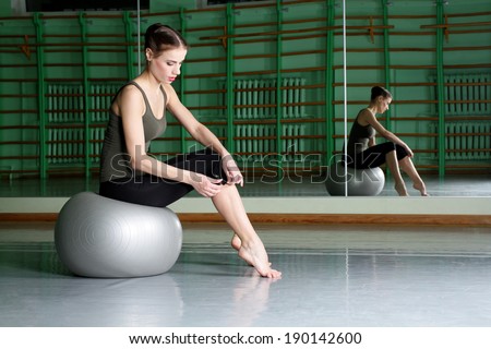 Woman sitting with exercise ball at dance hall