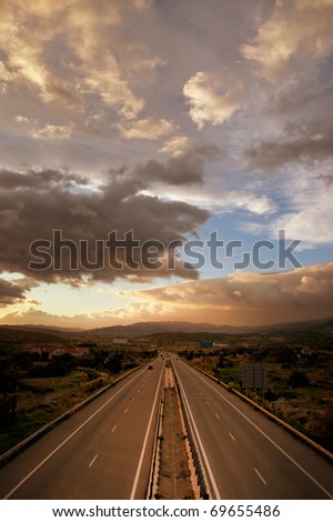 Beautiful dramatic cloudy sunset sky over highway