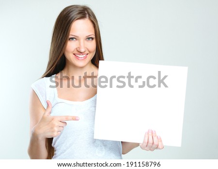 smiling happy woman holding  blank paper. empty copyspace for ads.