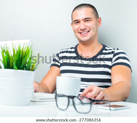 handsome man sitting at the table and using laptop computer