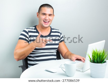 handsome man sitting at the table and using laptop computer