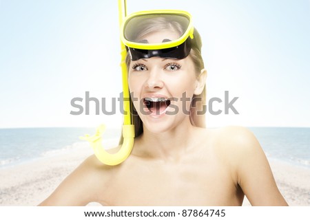 happy young woman in a swimming mask , on the beach
