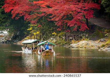 Arashiyama, Japan-25 Nov 2014: Group of Tourists cruising with blue jacket Japanese Ferryman in the River at Arashiyama on 25 Nov.