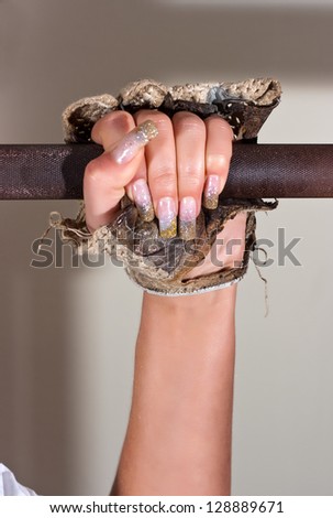 Attractive woman holding hand in glove weights