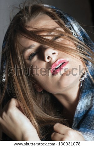 Portrait of a beautiful woman with a scarf, flying hair