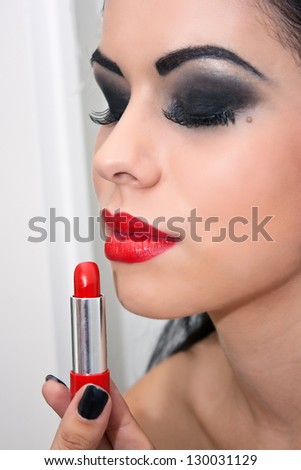 Beautiful woman with lipstick make a red lips