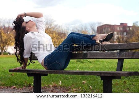 Attractive woman sitting on bench in park