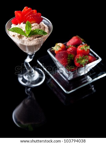 strawberries and chocolate mousse in a chilled martini glass with fresh mint garnish